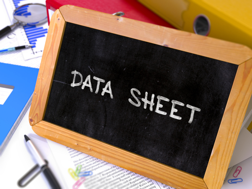 Data Sheet Handwritten on Chalkboard. Composition with Small Chalkboard on Background of Working Table with Ring Binders, Office Supplies, Reports. Blurred Background. Toned Image.